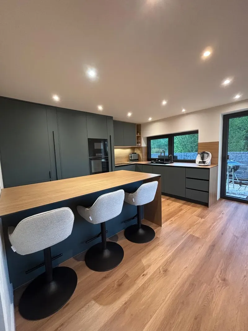 Cuisine anthracite avec îlot bar et plan effet bois