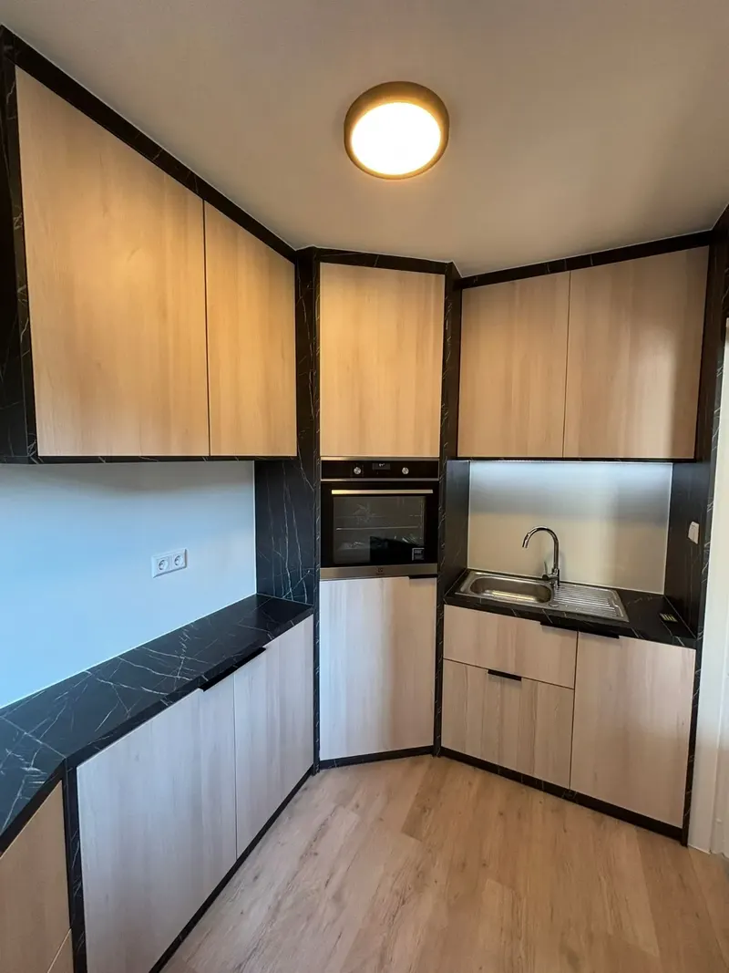 Cuisine d'angle avec meubles hauts effet bois et plan noir