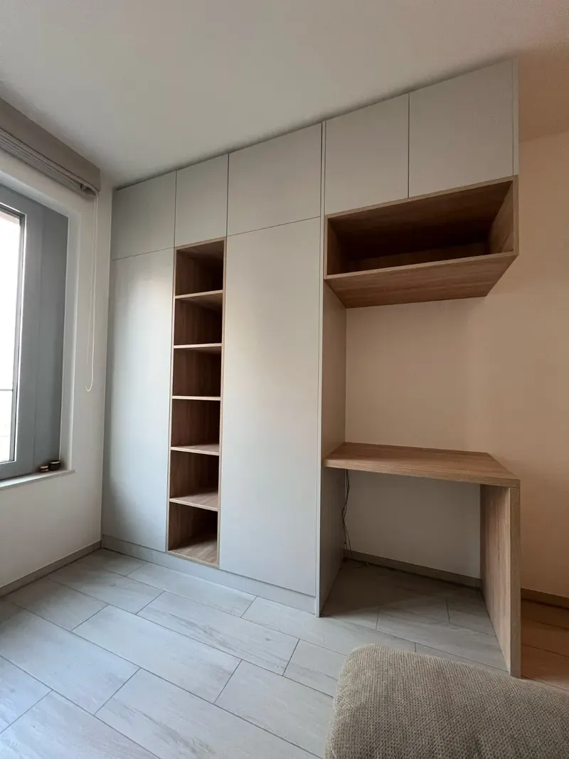 Mur de placards blancs avec étagères ouvertes et bureau intégré